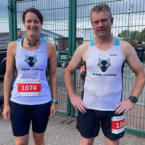 Two clients wearing running clothes with the Alpha Programme branding